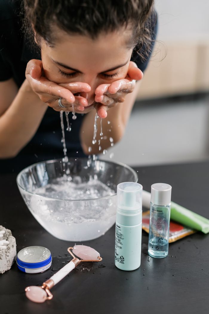 Crafting Captivating Headlines: Your awesome post title goes here A woman practicing her skincare routine with a face wash and products on a counter.